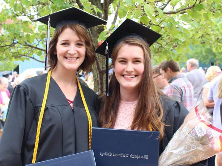 两位女毕业生在毕业典礼后站在外面